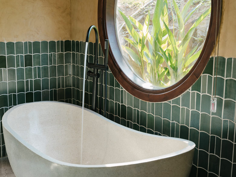 Sự kết hợp độc đáo giữa bồn tắm đá mài terrazzo và cây sen đặt sàn màu đen